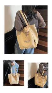 Détail du sac cabas en toile avec broderie bleue et breloque ours en peluche sur bois