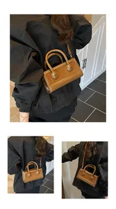 Detail of caramel glossy leather crossbody bag with round buckles and slim shoulder strap