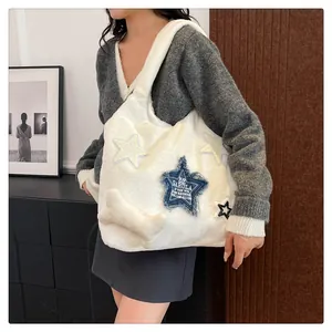 Detail of white plush tote bag featuring denim star patches and a cute bone charm
