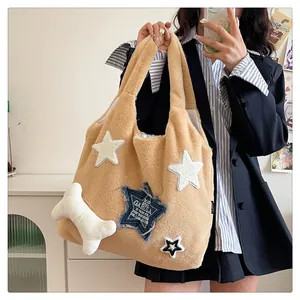 Detail of plush tote bag featuring star patches and white bone pendant accessory