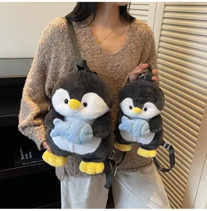 Detail view of cute penguin plush backpack with small fish accessory and adjustable straps