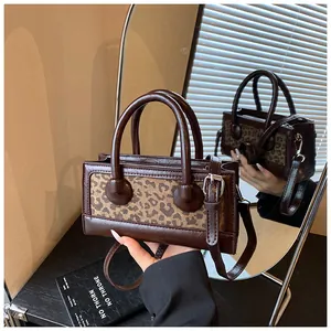 Detailed mirror view of a leopard print patchwork crossbody bag with sturdy handles