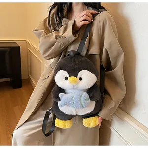 Detail of cute plush penguin backpack with small blue fish accessory and adjustable straps