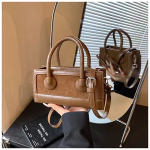 Close-up of brown patchwork handbag with suede texture and adjustable shoulder strap