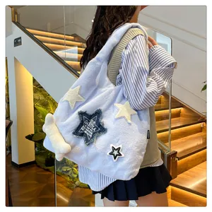 Detail of light blue plush tote bag with star patches and white bone plush pendant