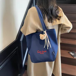 Sac cabas en toile bleu marine avec broderie et bijou d'ours sur un mannequin