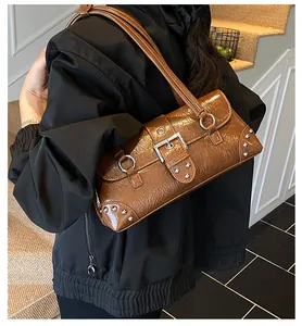 Brown wrinkled leather shoulder bag worn by model featuring silver rivet details