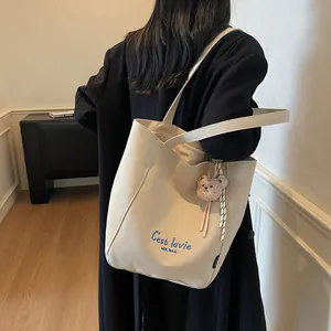 Sac fourre-tout minimaliste en toile blanc cassé avec broderie bleue et peluche d'ours