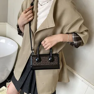 Fashionable leopard print patchwork crossbody bag with black handles and shoulder strap