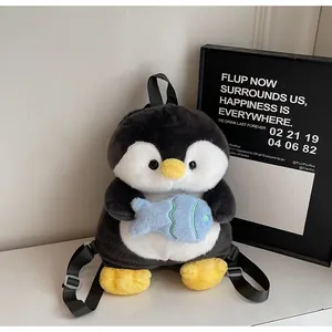 Detail of cute penguin plush backpack with blue fish accessory and adjustable straps