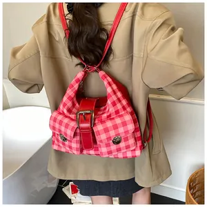 Detail of pink gingham backpack with red leather straps and metal twist-lock pockets