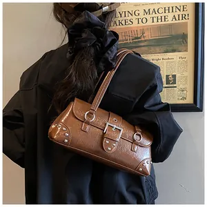 Macro detail of brown leather shoulder bag with vintage silver rivets and buckle