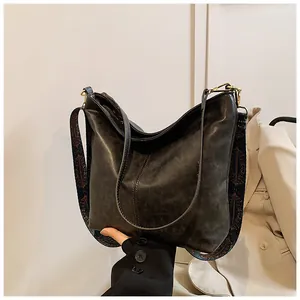 Détail du sac seau en cuir noir avec bandoulière large au motif ethnique coloré