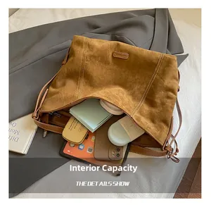 Interior view of large brown suede tote bag showing storage for tablet and cosmetics