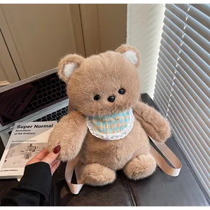 Detailed view of plush brown bear backpack with plaid lace bib and pink straps