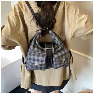 Close-up of classic grey plaid backpack with leather straps and silver twist-lock pockets