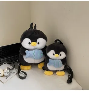 Plush penguin backpacks in two sizes showing soft fabric texture and blue fish decor