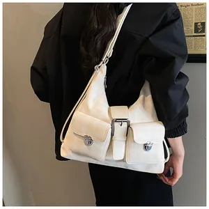 Close-up of cream checkerboard shoulder bag with metal turn-lock pockets and buckle