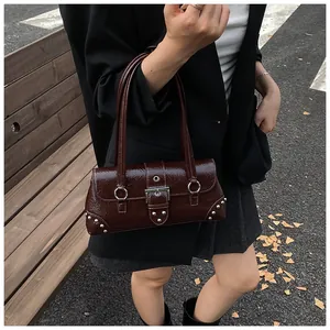 Detail view of dark brown patent leather shoulder bag with vintage crinkle texture and rivets