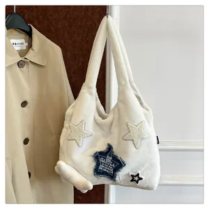 Detail of white plush tote bag featuring blue denim star patches with graphic print