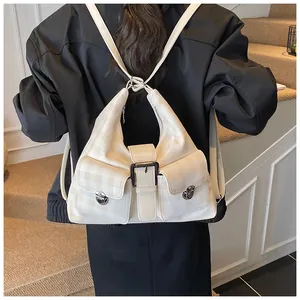 Detail of off-white checkered hobo bag featuring cargo pockets and metal buckles