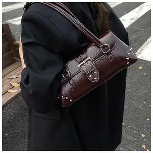 Close-up of vintage brown underarm bag with glossy patent texture and silver rivets