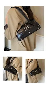 Detail of glossy black leather underarm bag with silver square buckle and metal rivets