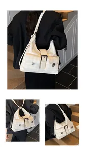 Close-up of beige plaid shoulder bag featuring dual front pockets with metal turn-lock closures