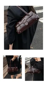 Detail of glossy burgundy leather shoulder bag with silver rivets and metal buckle straps