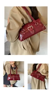 Detail view of burgundy faux leather shoulder bag with silver rivets and metallic buckles