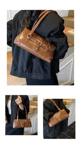 Detailed close-up of brown vintage leather bag with silver rivets and metallic buckle