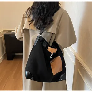 Detail of the large canvas tote bag with brown leather trim and silver metal hardware