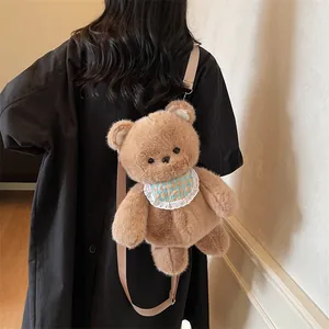 Cute brown plush bear backpack with checkered bib worn by model in cozy interior setting
