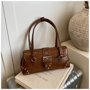 Macro detail of dark brown baguette bag with pleated texture and silver metal buckle