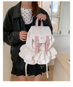 Detailed view of polka dot backpack with pink leather straps and ruffled layering design
