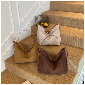 Detailed view of three large capacity Hobo shoulder bags in beige, camel, and brown colors