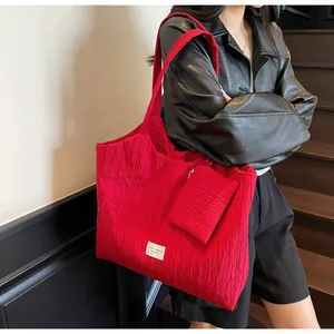 Détail d'un sac cabas plissé rouge avec grande capacité et une pochette assortie incluse