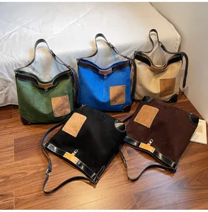 Detailed arrangement of suede tote bags in various colors with leather corner patches