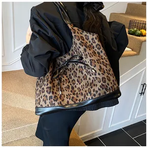 Détail du sac cabas léopard avec bordures en cuir noir et petit nœud décoratif