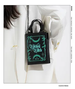 Detailed view of Wicked Witch book-shaped handbag with chain strap on white blazer