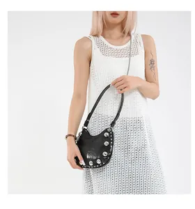Detail of black crescent hobo bag featuring large silver rivets and dual chain strap