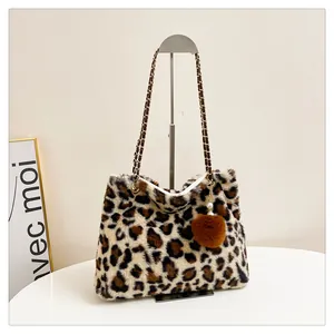 Dettaglio borsa tote in peluche leopardato con catena dorata e ciondolo pompon