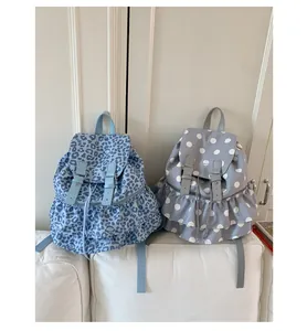 Detailed view of polka dot and leopard print backpacks with ruffled hem and leather straps
