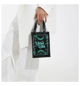 Detail of black faux leather tote with Wicked Witch of the West print and silver hardware