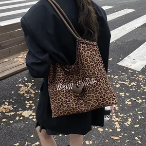 Large leopard print tote bag with embroidery, shown as a shoulder bag on a model
