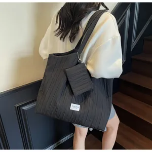 Détail du grand sac cabas plissé noir avec sa pochette zippée assortie et logo