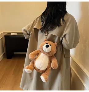 Brown teddy bear plush crossbody bag worn by a model in a stylish trench coat