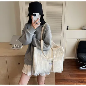 Détail du sac cabas en toile plissée crème avec sa petite pochette assortie