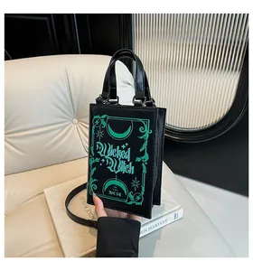 Close-up of black book-shaped bag featuring green Wicked Witch of the West print