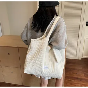 Gros plan d'un sac cabas en toile beige montrant la texture du tissu et l'étiquette